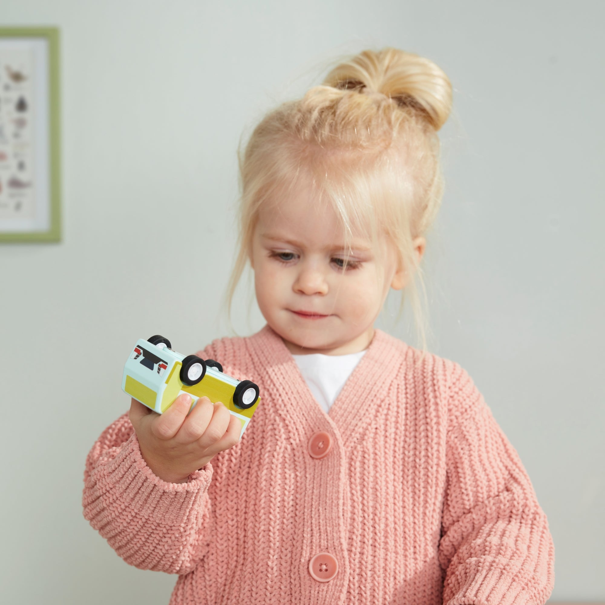 Kislány fa autóra néz rózsaszín kardigánban - Gyorsuló autók - pippadu