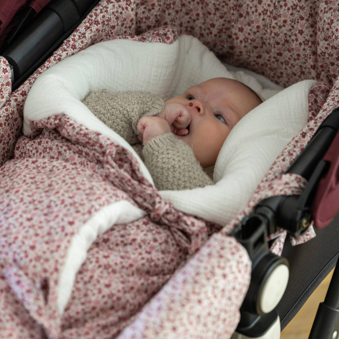 Kisbaba a babakocsiban pihen virágmintás babafészekben a Pasito a Pasito márkától