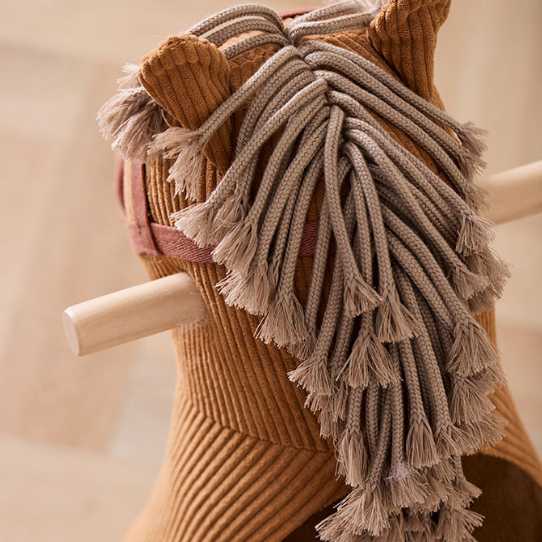 Közelkép a Kid's Concept Vera barna kordbársony hintaló füleiről és fonott sörényéről, mutatva a prémium textil textúráját