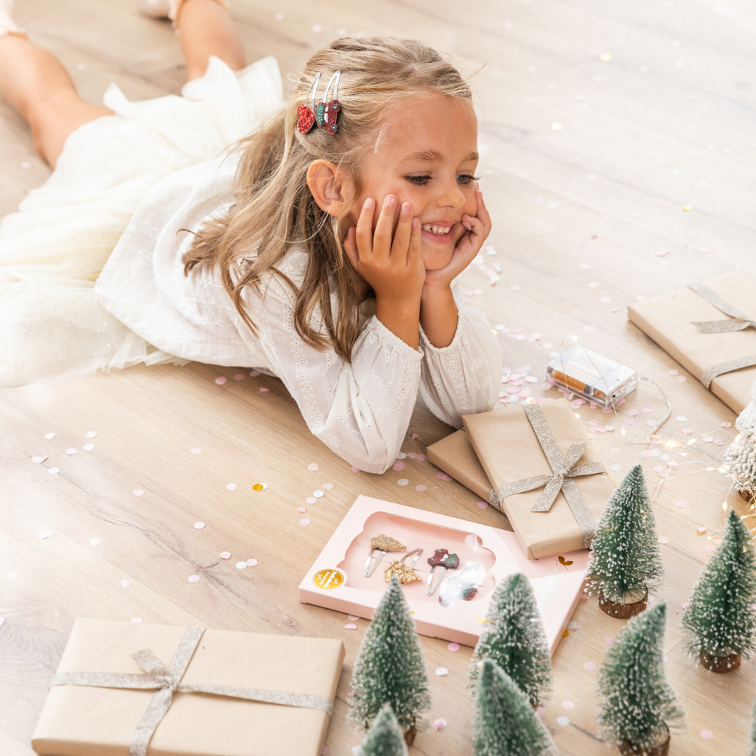 Kislány karácsonyi ajándékokkal - ajándékdoboz négy hajcsattal: két kisautó, két karácsonyfa mintás