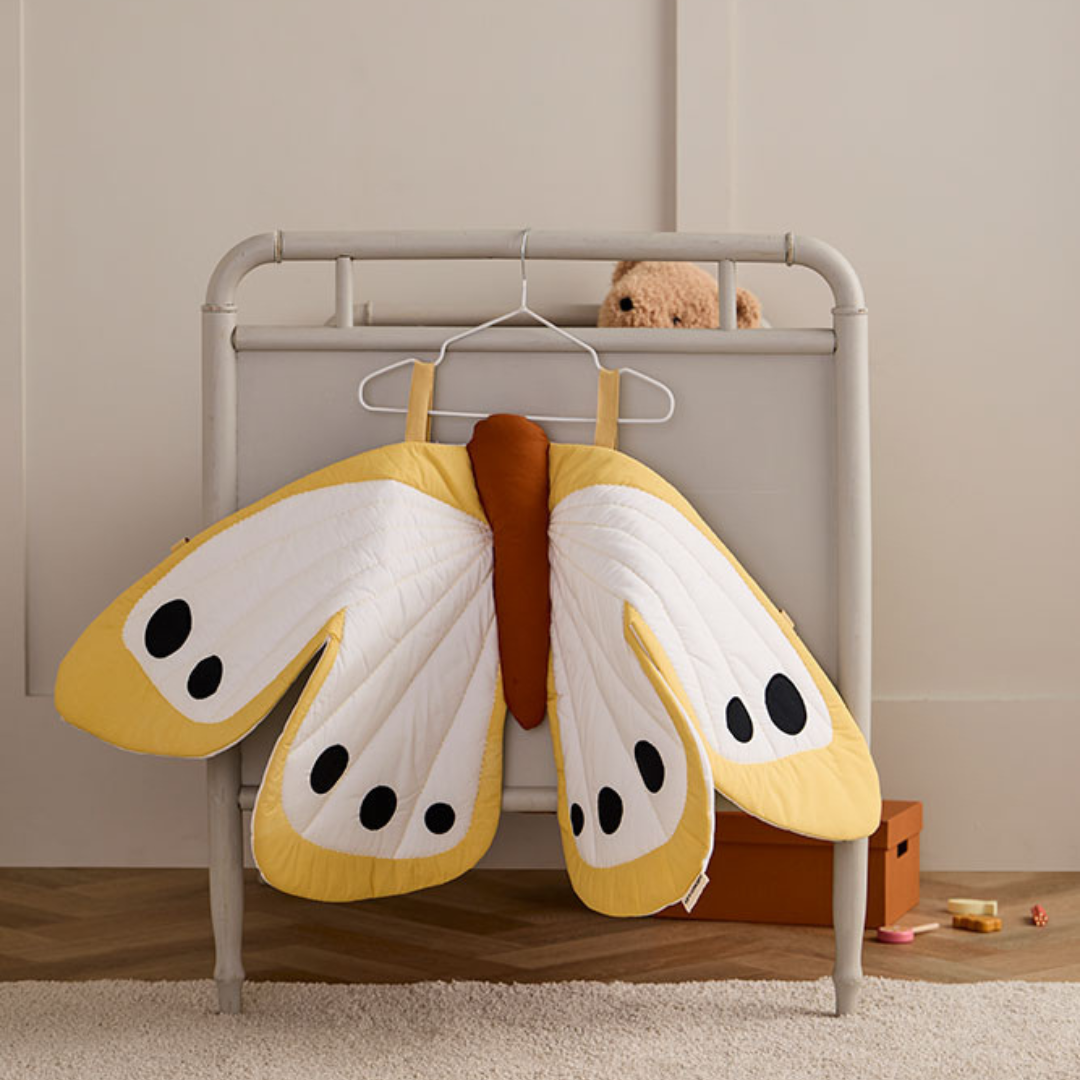 Sárga pillangó jelmez vállfán, gyerekszoba ágyvégére akasztva