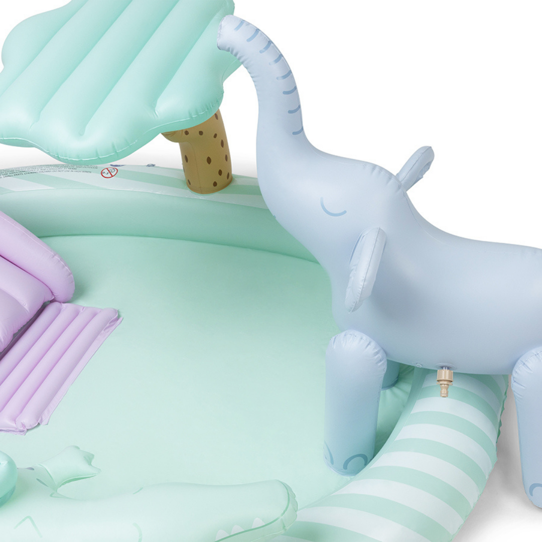 Közelkép a Swim Essentials medencéhez tartozó kék felfújható elefántról, ami vizet permetez.