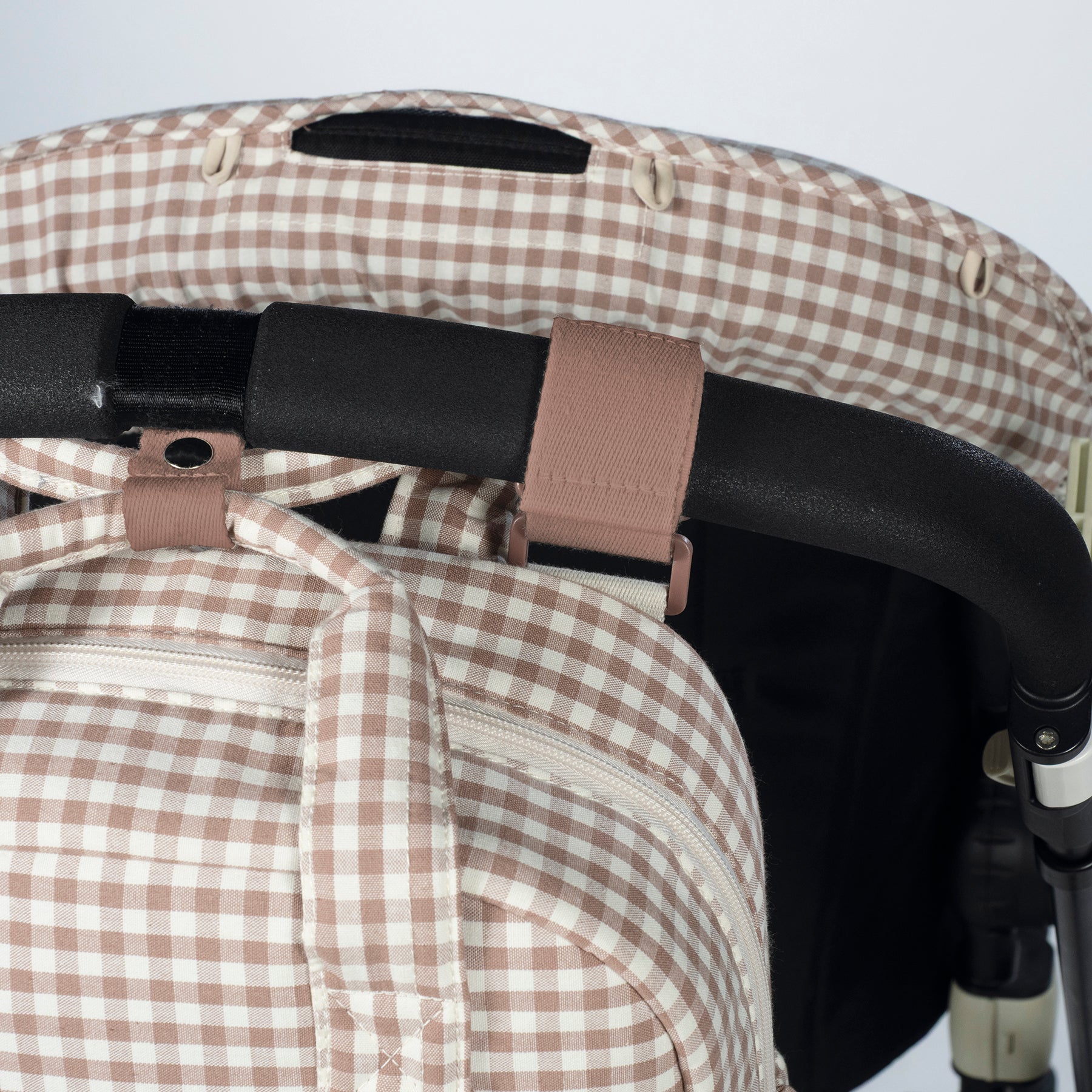 Walking Mum Praliné rózsaszín kockás pelenkázó hátizsák babakocsira rögzítve közeli kép