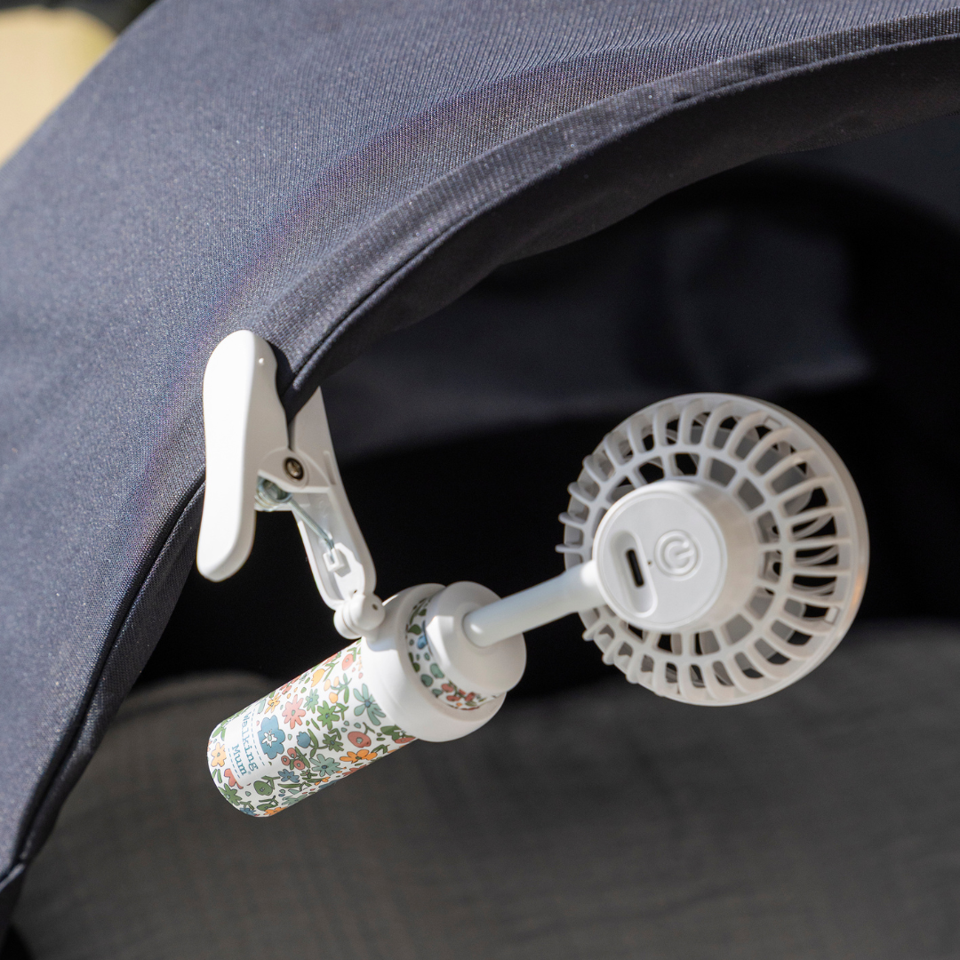 Virágmintás babakocsi ventilátor a babakocsi fekete kupolájára csíptetve