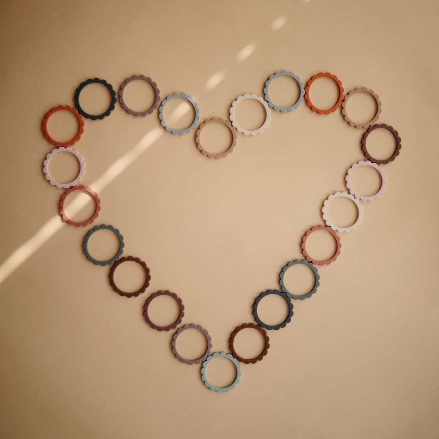 Virágos rágóka - fekete-karamell-bézs színben az amerikai mushie márkától - pippadu