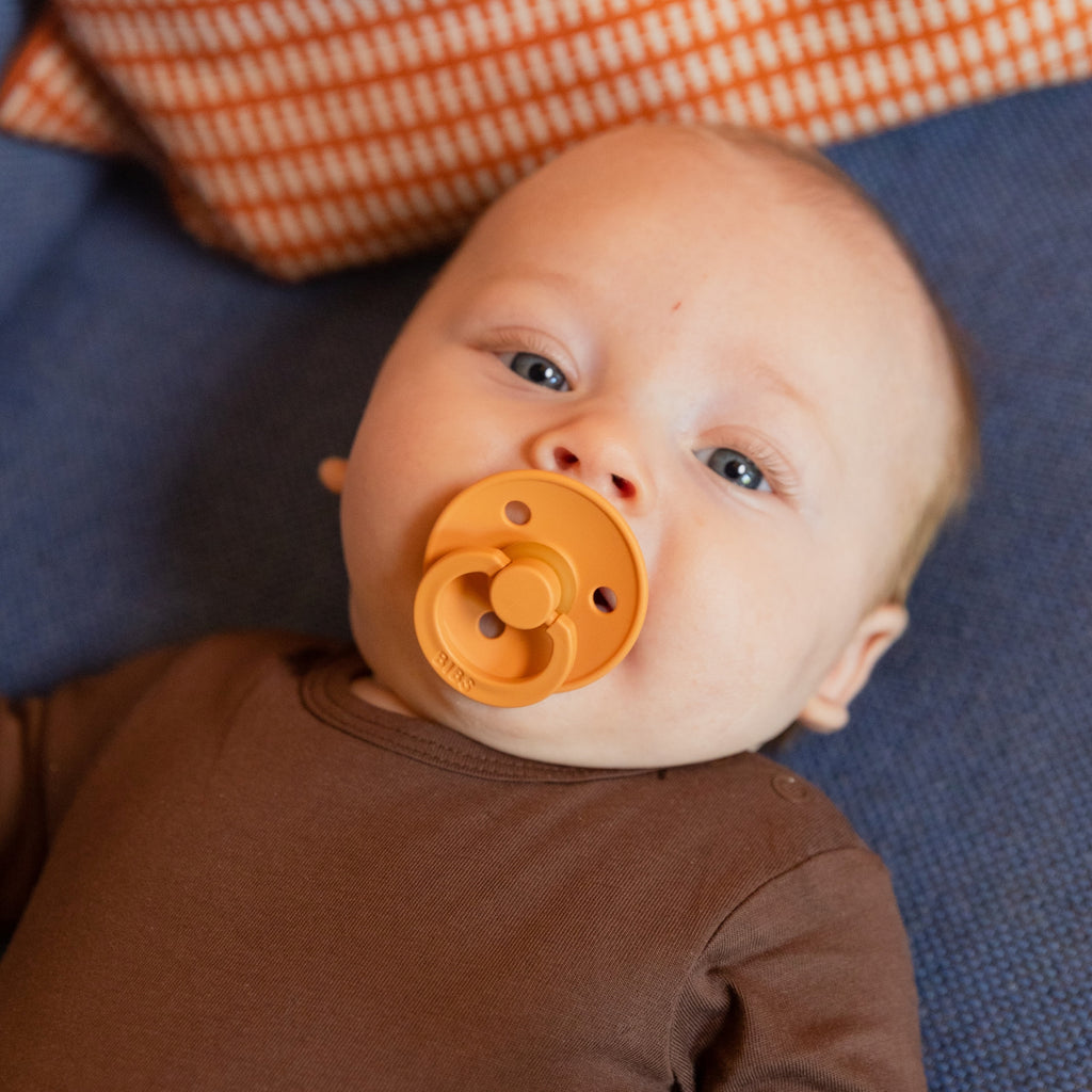 Kisbaba cumival a szájában kék takarón fekszik - kisbaba fotózás - BIBS Colour cumi - pippadu