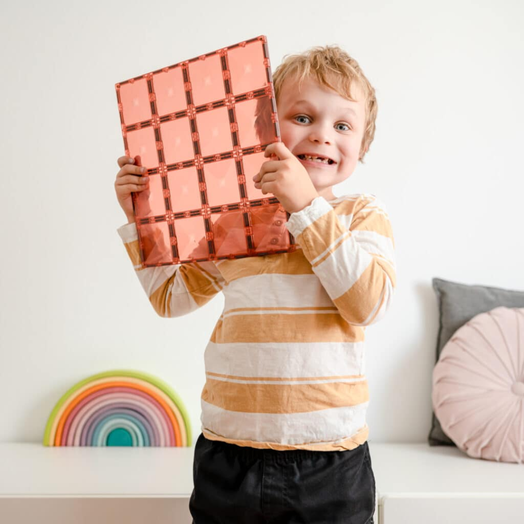 Kisfiú egy CONNETIX mágneses alaplapot tart a kezében barack színben