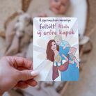 Kézben tartott Modern Goddess anyaság kártya A gyermekem mosolya feltölt felirattal, háttérben egy kisbabával.