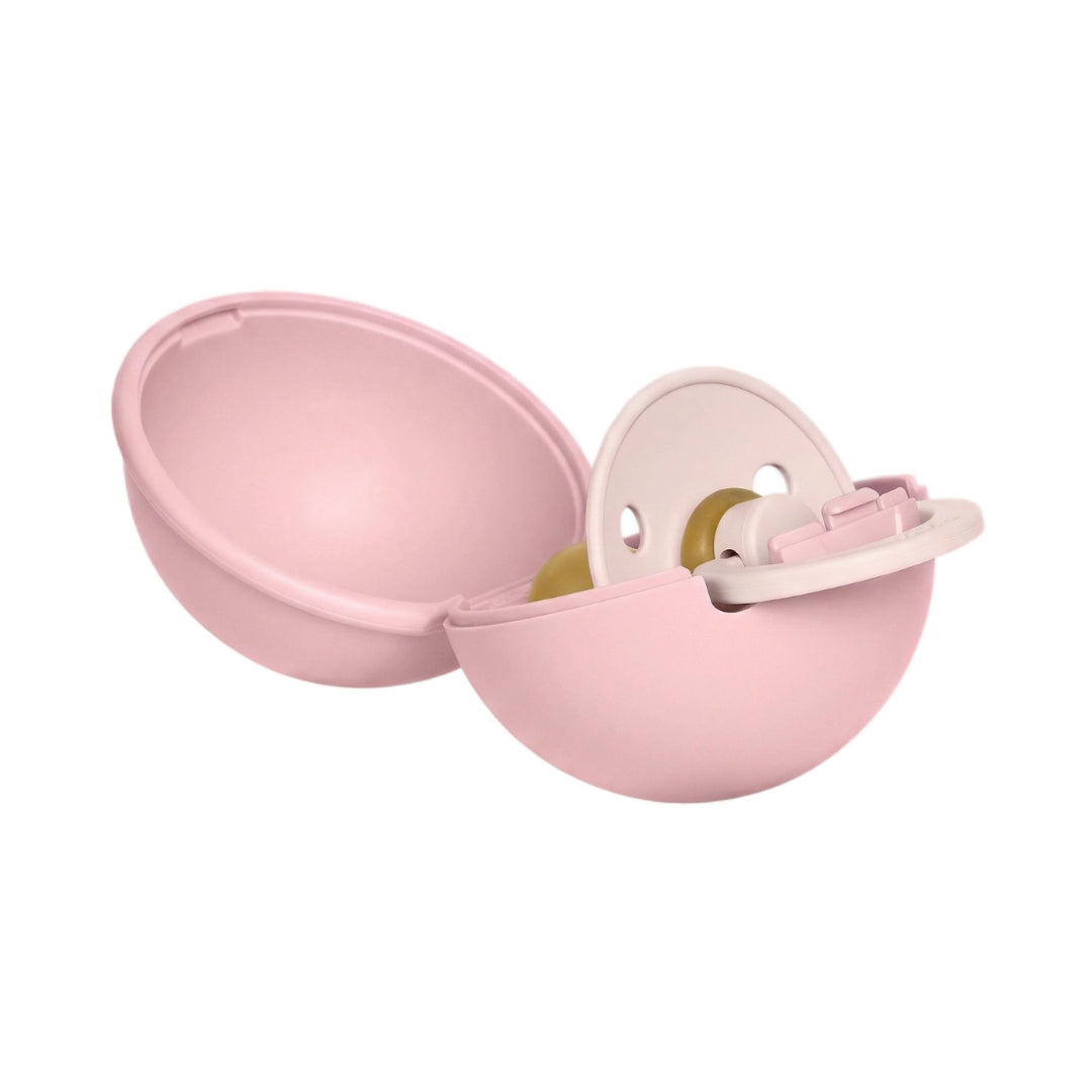Egy kézzel nyitható babarózsaszín BIBS mini cumitartó félig nyitva, benne a BIBS Colour cumival.