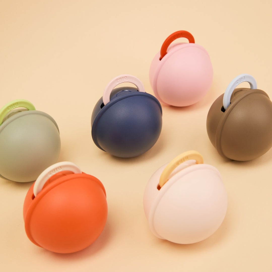 Különböző pasztell színű BIBS mini cumitartók a bennük lévő cumik fogantyúival