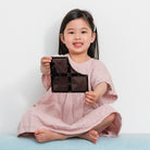 CONNETIX mágneses építőjáték - felüljárók és kereszteződések (16 db) csomag fekete elemét fogja egy kislány