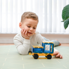 Kisfiú autóval játszik, amit a Connetix autóalappal épített meg, igazi gumikerekekkel