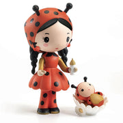 Djeco Tinyly Katica Bogival (Coco & Minico) – pöttyös ruhás katicalány figura cumisüveggel, mellette Bogi, a kis katicababa százszorszép bölcsőben