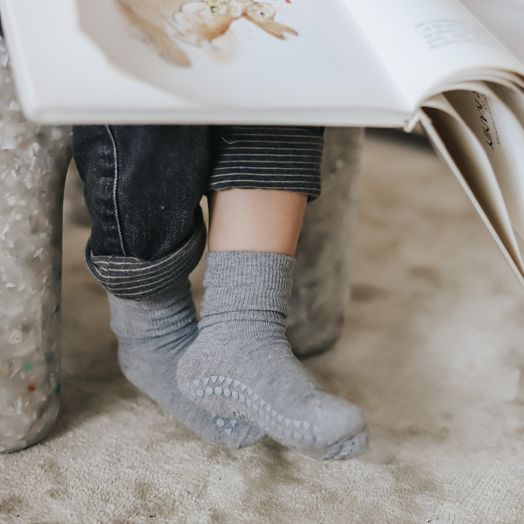 Olvasó kisgyerek lábán szürke csúszásgátlós bambusz zokni 