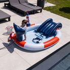 Gyermek játszik a medencében a felfújható világítótorony és a spriccelő bálnafarok mellett.