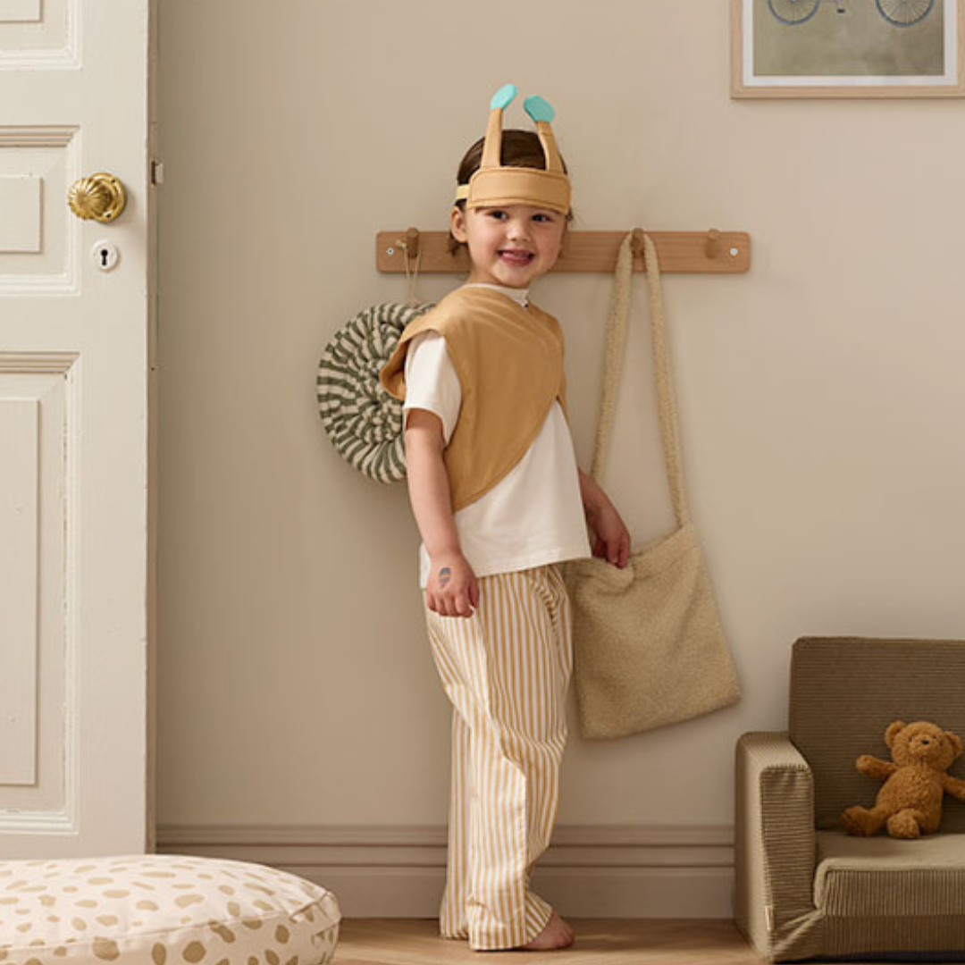 Kislány mosolyog a gyerekszobában Kid's Concept csiga jelmezben