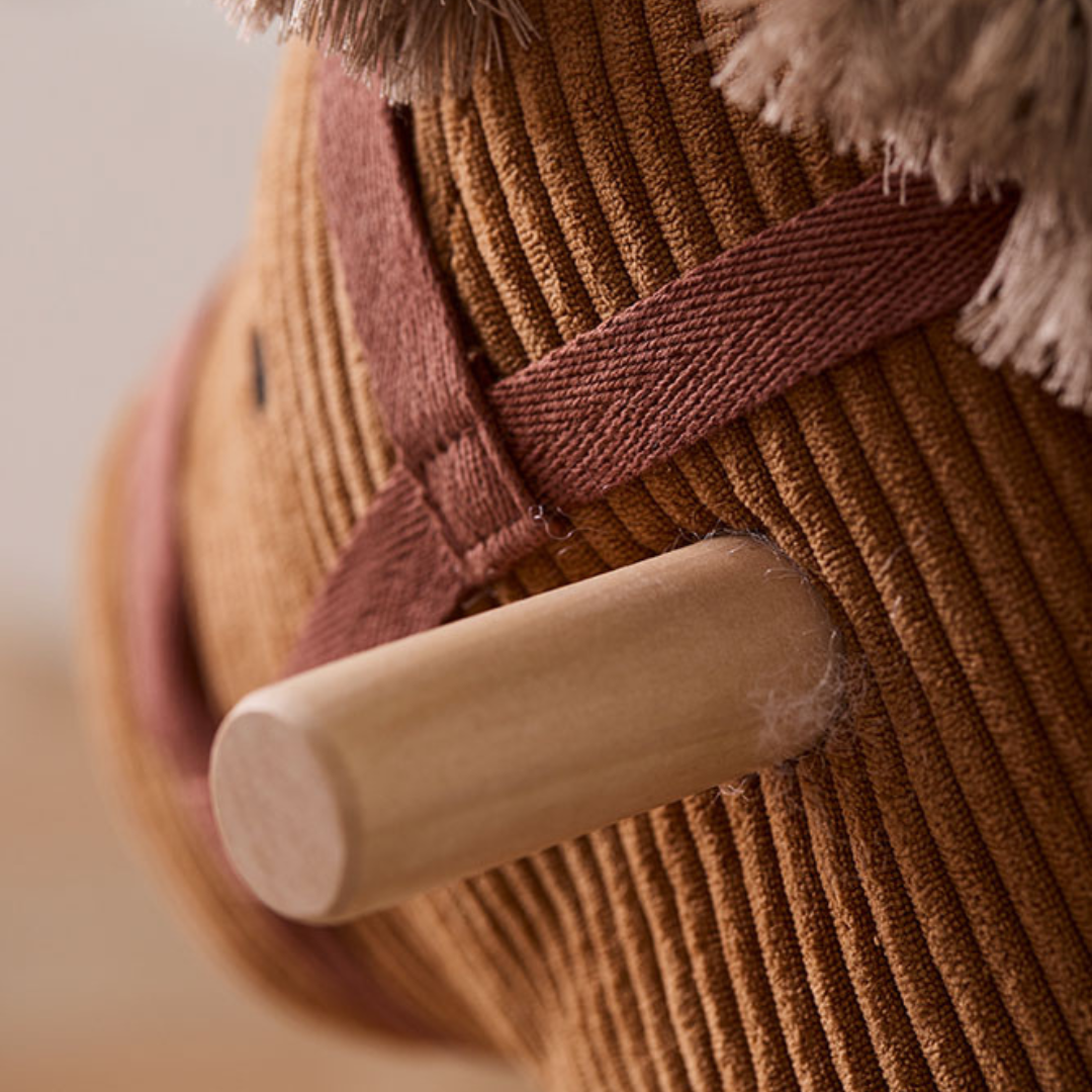 A Kid's Concept Vera barna kordbársony hintaló feje profilból, jól látható natúr fa fogantyúval és a hám részleteivel