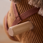 A Kid's Concept Vera barna kordbársony hintaló feje profilból, jól látható natúr fa fogantyúval és a hám részleteivel