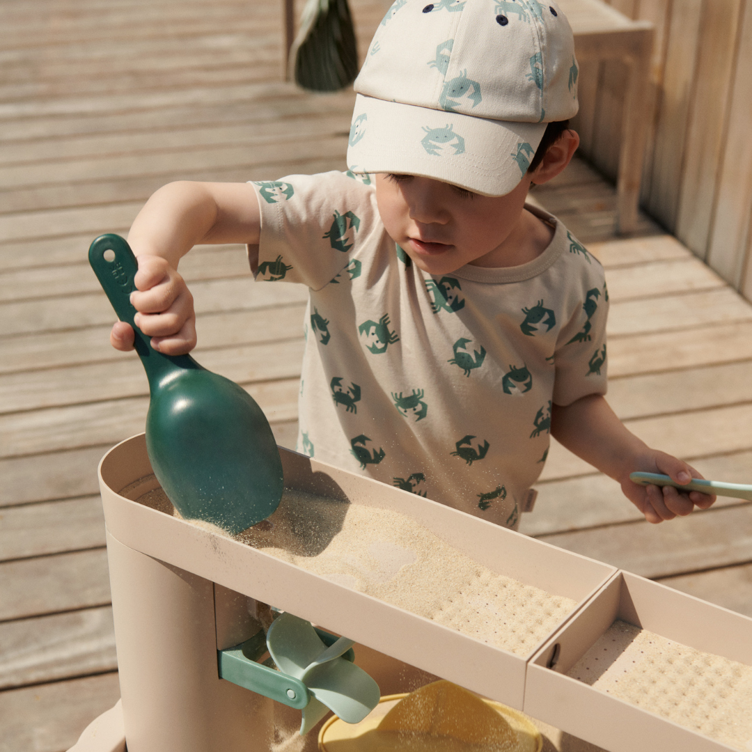 gyerek homokot önt a Liewood Sepp játékasztal felső részén