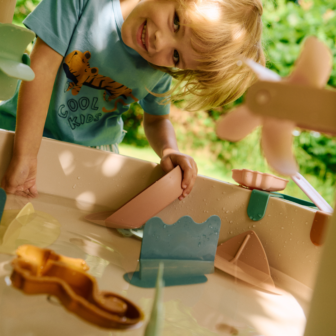 kisgyerek örömmel játszik a Liewood Sepp játékasztallal