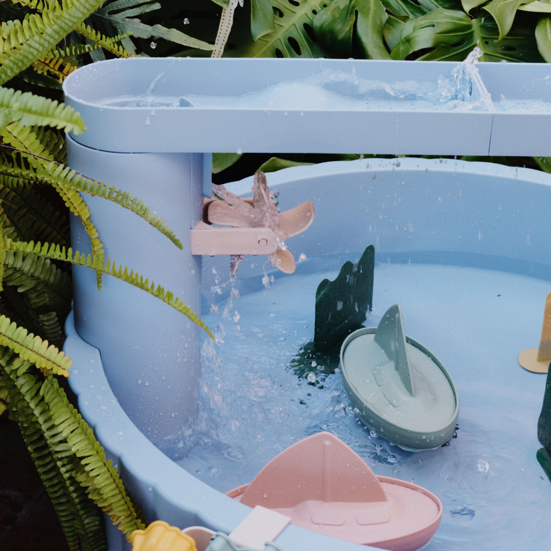 Kék vizező játékasztal vízimalommal és folyó vízzel játék közben