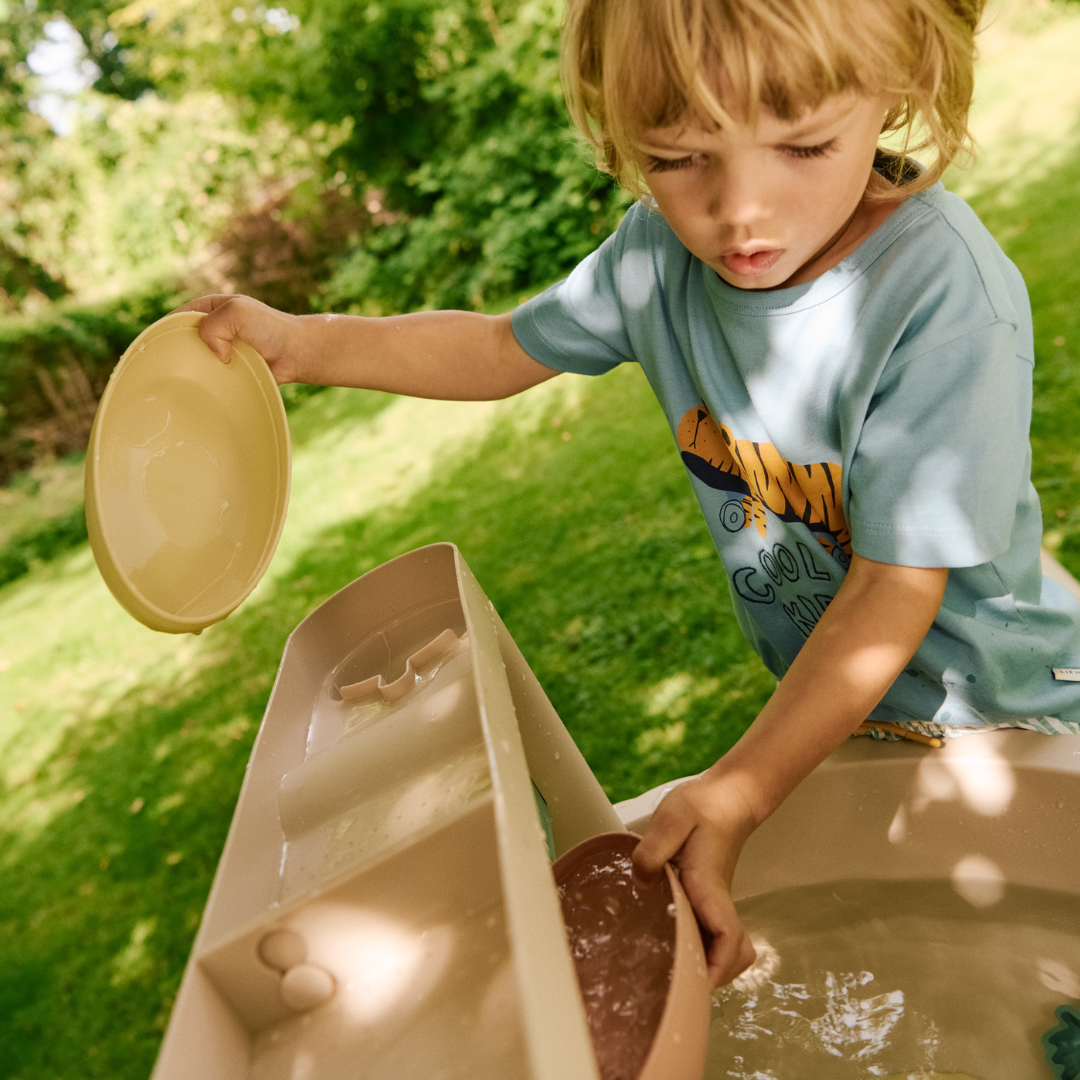 gyerek vízzel játszik a Liewood Sepp játékasztalon közelről
