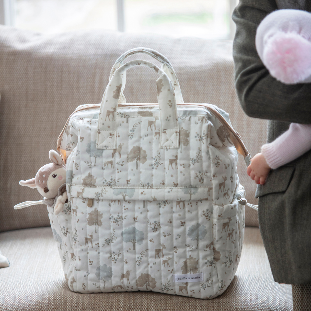 Fehér alapon mintás pelenkázó hátizsák párnázott vállpántokkal, rövid, könnyen fogható fülekkel, oldalsó zsebekkel