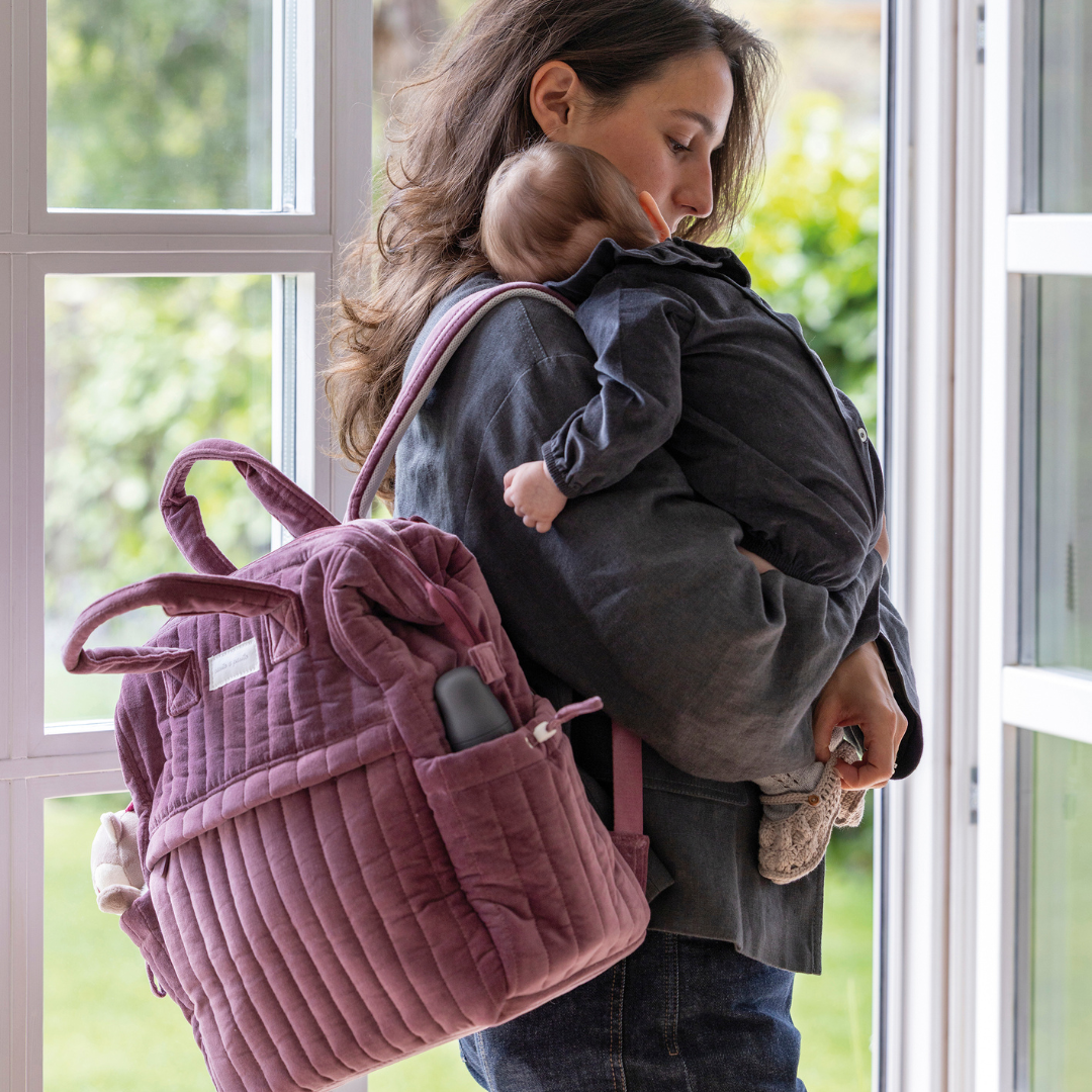 Kisbaba édesanya kezében alszik, anyuka hátán bársony Pasito a Pasito pelenkázó hátizsák BIBS cumisüveggel