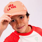 Kisfiú piros-fehér csíkos Sea La Vie baseball sapkában és hozzá illő UV-szűrős pólóban.