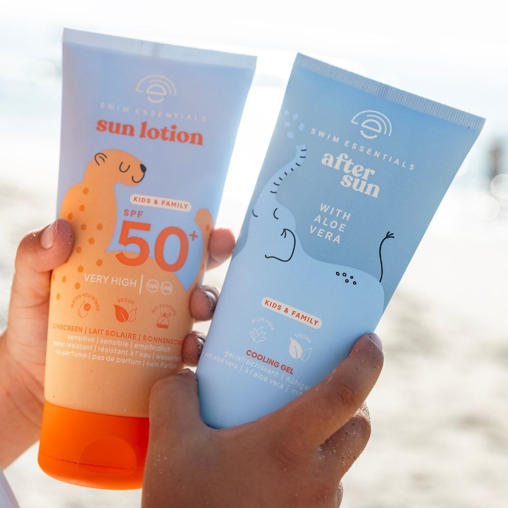 Swim Essentials SPF 50+ naptej és hűsítő napozás utáni gél együtt a tengerparton.