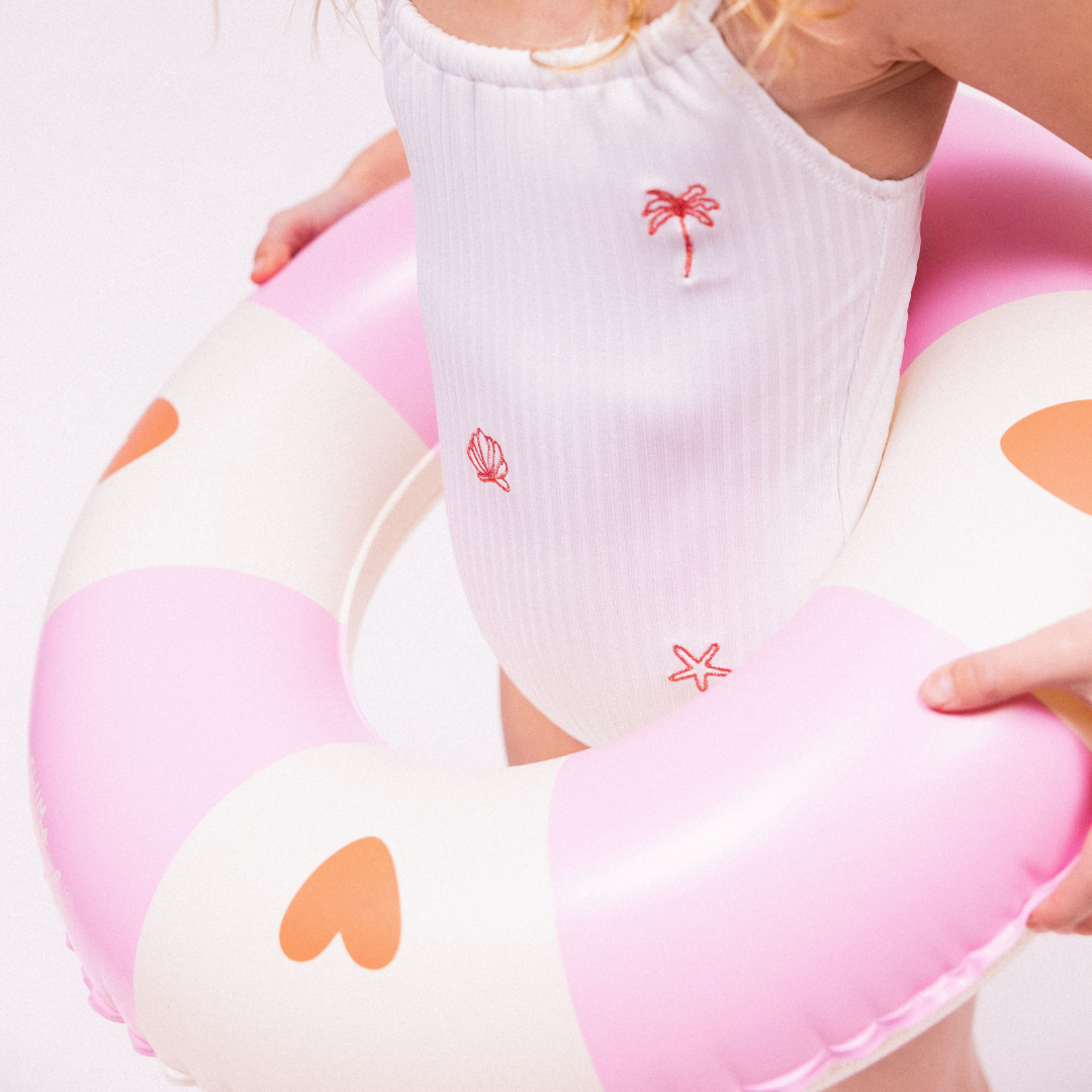 Közelkép a Swim Essentials szíves úszógumi puha anyagáról és a minőségi mintájáról.