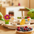 Ünnepi fa gyertyakoszorú gyertyákkal terített asztalon – húsvéti asztaldekoráció természetes anyagból