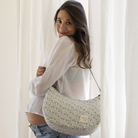 Kismama gondola menta színű pelenkázó táskával a vállán a kamera név az ablak előtt állva