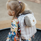 Kislány kiskutyás gyerek hátizsákkal trambulinon ugrál a játszótéren