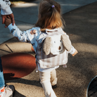 Kislány a játszótéren Walking Mum gyerek hátizsákkal a hátán - kiskutyás minta, csíkokkal