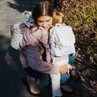 Virágos gyerek hátizsák fodros részletekkel, aranyos állatos kiegészítővel  - kislány és anyukája összeillő pulóverben és hátizsákban a Városligetben