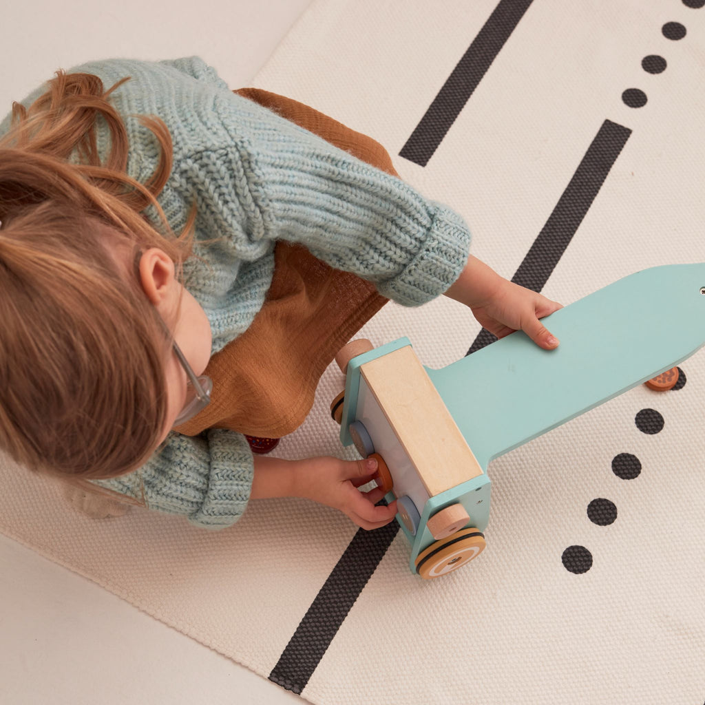 Kislány fa játék porszívó alját nézegeti a szőnyegen - pippadu - Kids Concept