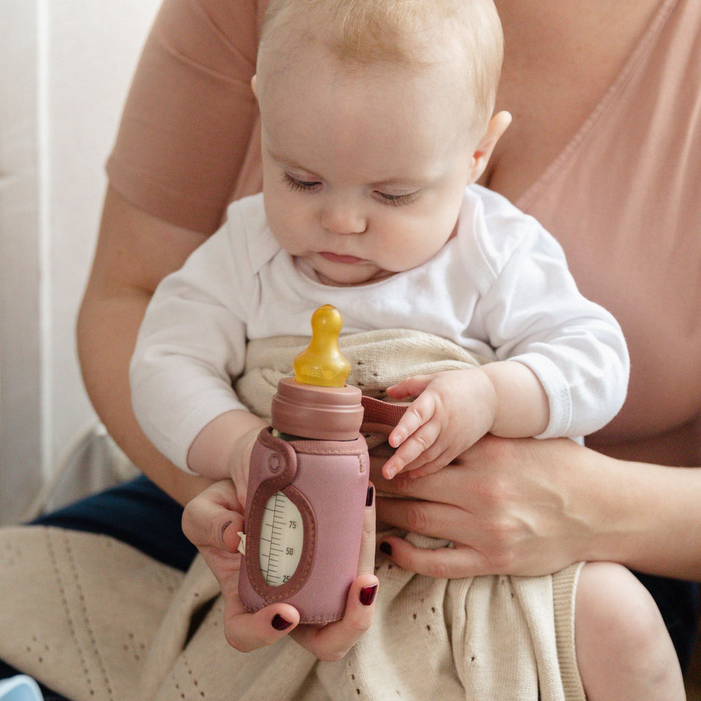 Kisbaba üveg cumisvegre néz mackó védőtokban, édesanya ölében - pippadu