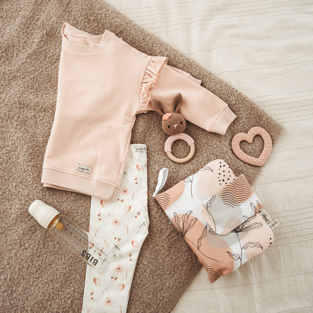 Gyerek pulóver és leggings baba kiegészítőkkel ágyon - pippadu