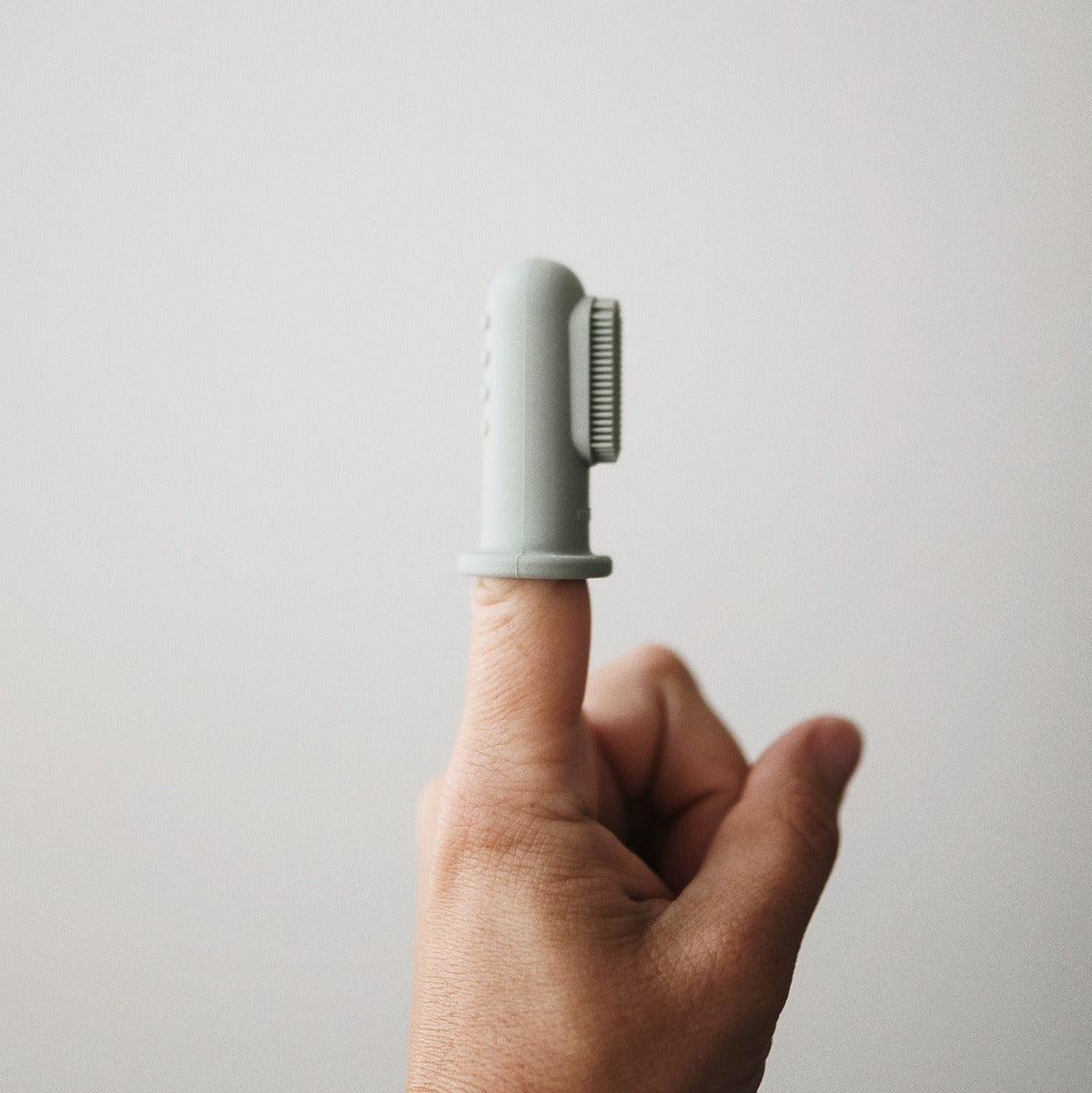 Élelmiszeripari szilikonból készült ujjra húzható fogkefe halvány türkiz és homok színben a pippadunál, az amerikai mushie márkától